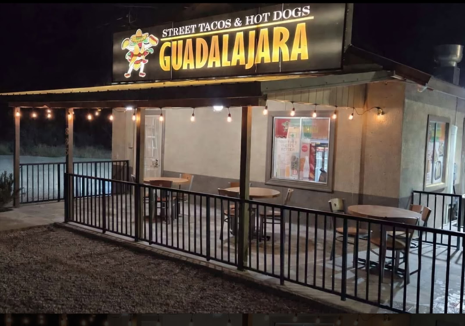 Exterior of Guadalajara Street Tacos & Hotdogs in Bisbee with an illuminated storefront sign
